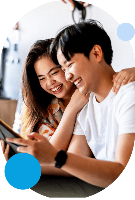 Joyful couple laughing while looking at the tablet